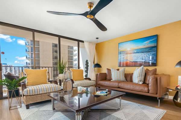Living room with comfortable sofa, coffee table, ceiling fan, and 2 armchairs