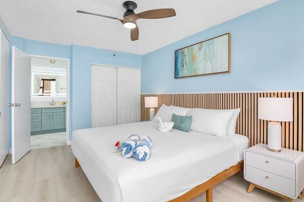Bedroom with king-size bed, closet, ceiling fan, and access to the bathroom.