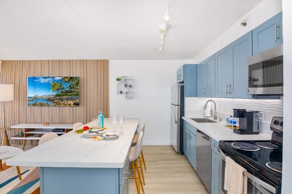 Fully equipped kitchen with full-size appliances, and dining area with 4 bar stools.