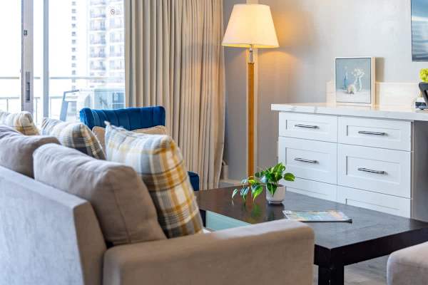 In the living area, it has a blue accent chair and a floor lamp.