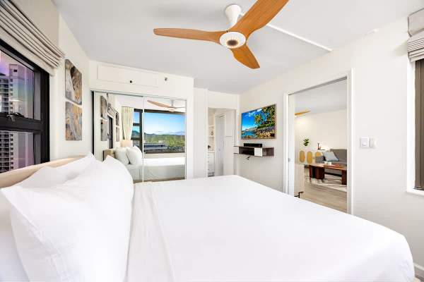 Bedroom with King-sized bed, 50" Smart TV, ceiling fan, and access to the bathroom