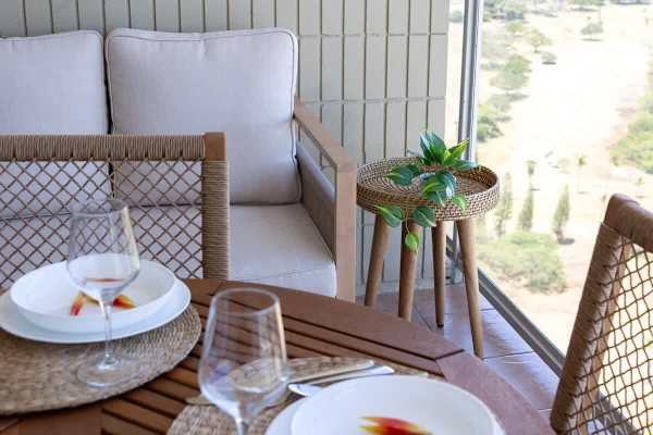A refreshing dining area complete with a table, 3 chairs, and a couch located on your balcony!