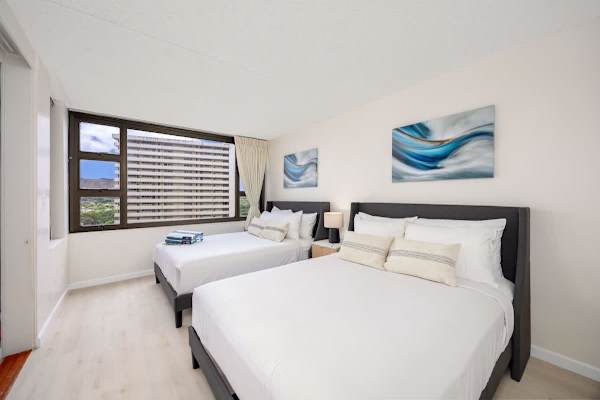Unwind comfortably in this bright bedroom featuring two plush Queen-size beds, perfect for a relaxing stay with beautiful views from the large window