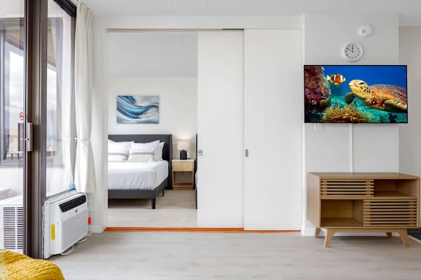 The bedroom has 2 queen-size beds and is separated from the living room by a sliding door