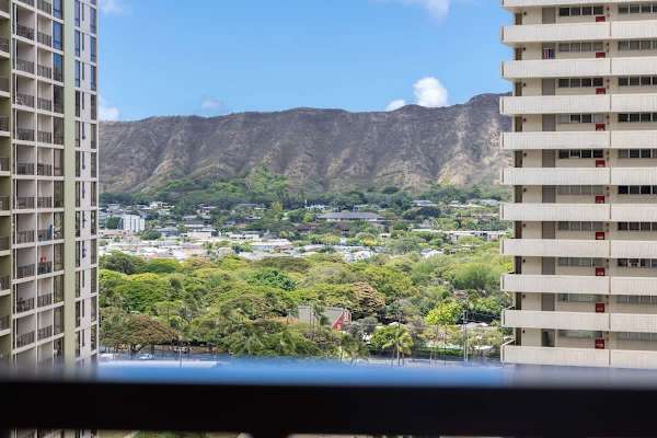 Marvel at the stunning panoramic views from the balcony encompassing a vibrant cityscape, and the iconic Diamond Head in the distance