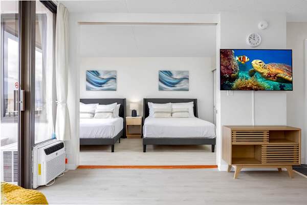 The bedroom has 2 queen-size beds and is separated from the living room by a sliding door