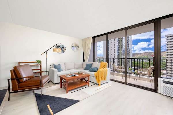 Relax in the living room, which features a comfortable sectional sofa, leather armchair, coffee table, and stylish decor