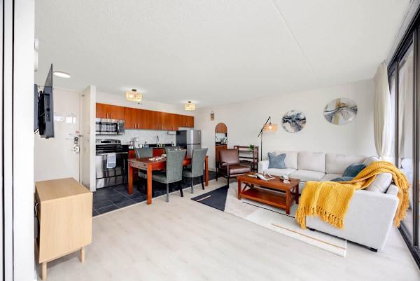 Discover this bright and airy open-concept living space, seamlessly blending a fully equipped modern kitchen, a dedicated dining area, and a comfortable living room with balcony access