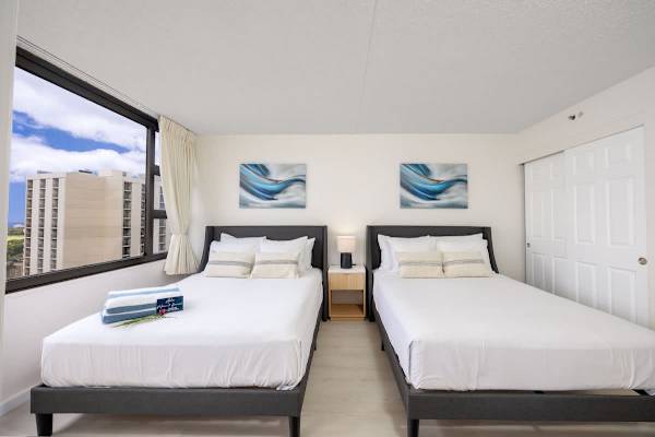 Enjoy a comfortable stay in this bright bedroom featuring 2 Queen-size beds, ample storage in the closet, and scenic views through the large window