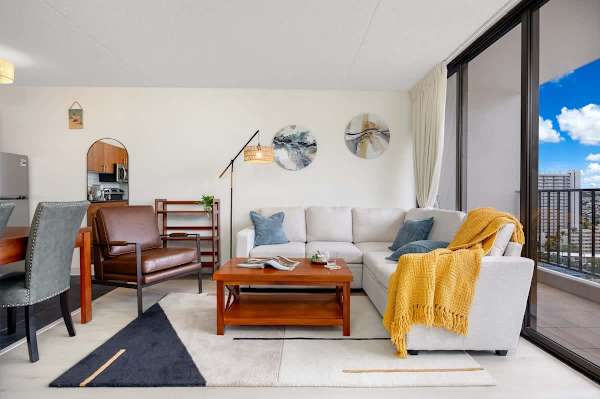 Relax in the living room, which features a comfortable sectional sofa, leather armchair, coffee table, and stylish decor