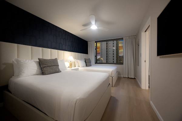 Retreat to this serene bedroom where the soft glow of the bedside lamp perfectly sets the mood for a cozy Hawaiian night.
