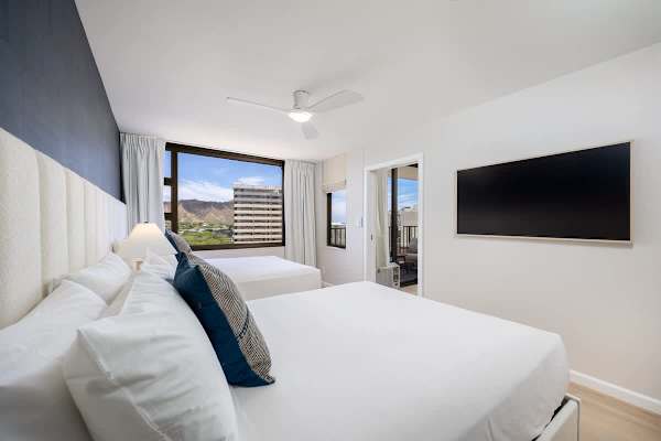 Unwind in your bedroom, offering 2 queen beds, a 55" flat-screen TV, and seamless access to the unit's living space and bathroom for ultimate convenience.