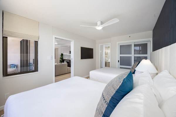 Unwind in your bedroom, offering 2 queen beds, a 55" flat-screen TV, and seamless access to the unit's living space and bathroom for ultimate convenience.