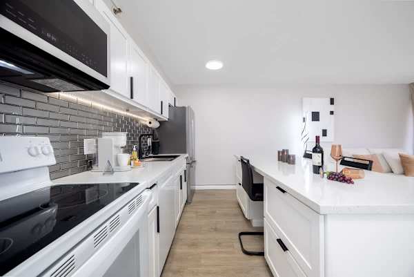 Cook with ease in our pristine kitchen, featuring a full-sized refrigerator, microwave, oven, and stovetop for all your culinary adventures.