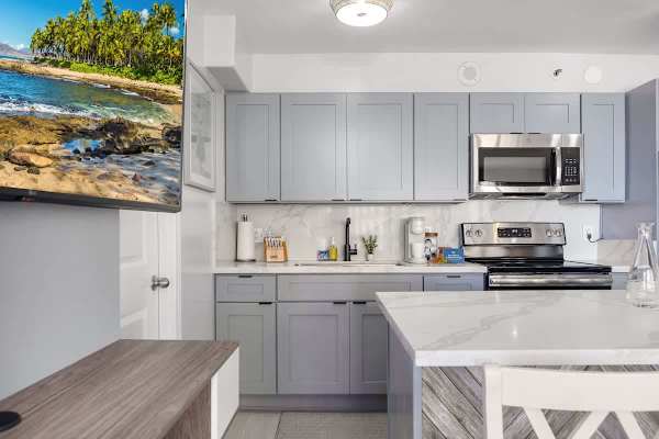 Prepare delicious meals in this modern and fully equipped kitchen, featuring sleek cabinetry, stainless steel appliances, and ample counter space.