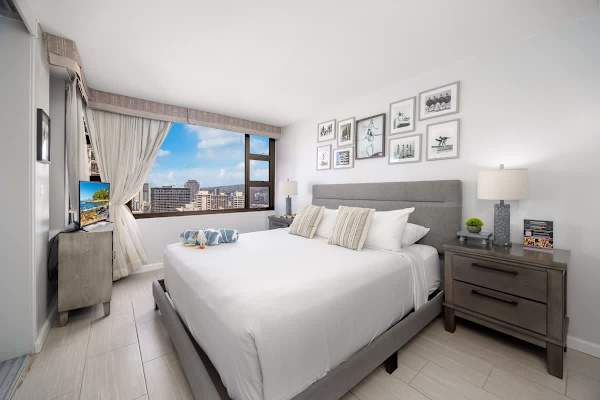 Relax in your bedroom, which offers serene comfort with a plush king bed, modern decor, and captivating city views right from your window, ensuring a restful and inspiring stay.