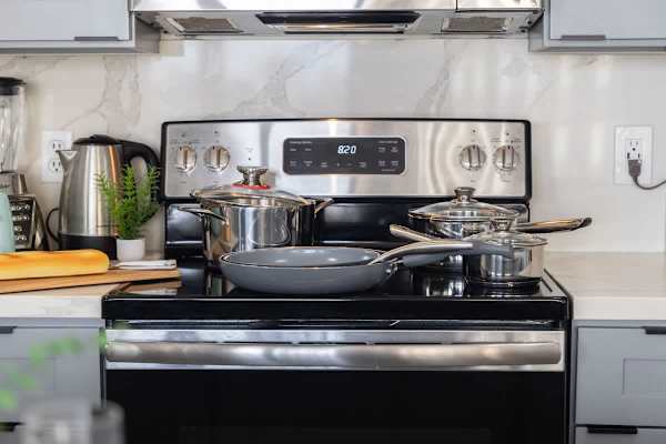Cook with ease in this well-equipped kitchen featuring a modern stove and oven, complete with all the essential cookware.