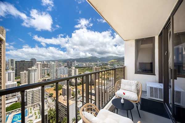 Relax and unwind on your private lanai, offering breathtaking vistas of the urban landscape and lush green hills.