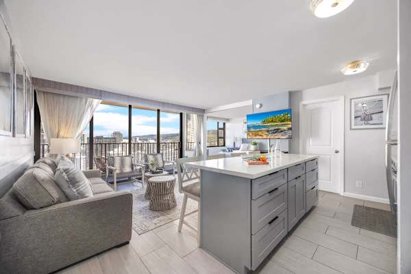 This chic unit offers a seamless flow from the stylish kitchen island to the inviting living room with expansive windows showcasing vibrant city views.