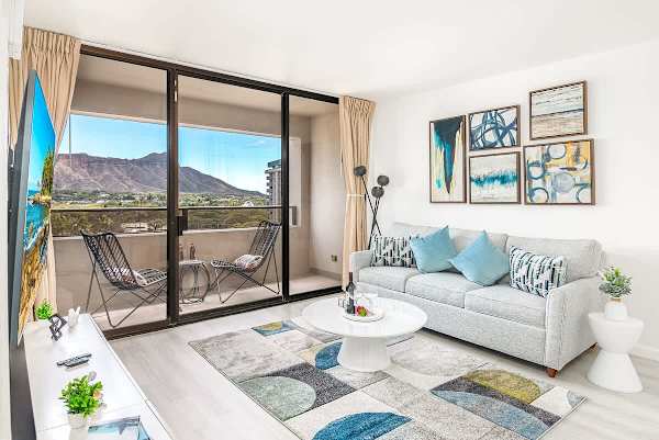 Relax in the stylish living room, featuring a pull-out sleeper sofa and a private balcony with stunning views of Diamond Head, perfect for enjoying a glass of wine or your morning coffee.
