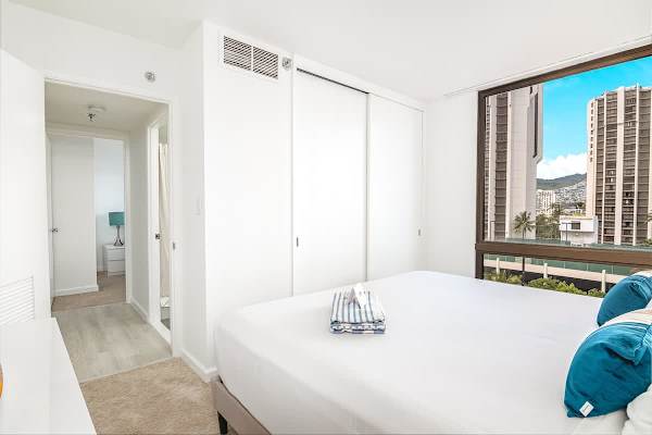 Relax in the tranquil main bedroom, featuring a plush king-sized bed, a closet, and a 43" smart TV for entertainment.