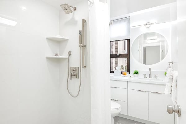 Freshen up in the sleek and modern bathroom, featuring a walk-in shower and contemporary fixtures for a refreshing experience.
