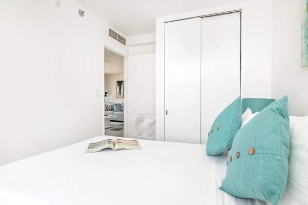 This bright second bedroom offers a full-size bed, ample closet space, and a serene atmosphere, ensuring a restful stay.