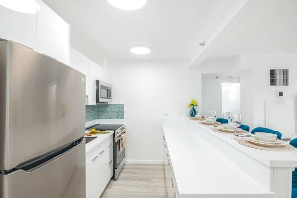 Prepare your favorite meals in the sleek, fully-equipped kitchen, featuring modern appliances and a convenient breakfast bar perfect for casual dining.