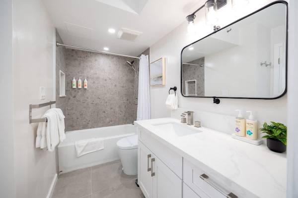 Refresh and rejuvenate in this bright and modern bathroom featuring a spacious vanity with ample counter space and a sleek shower-tub combo.