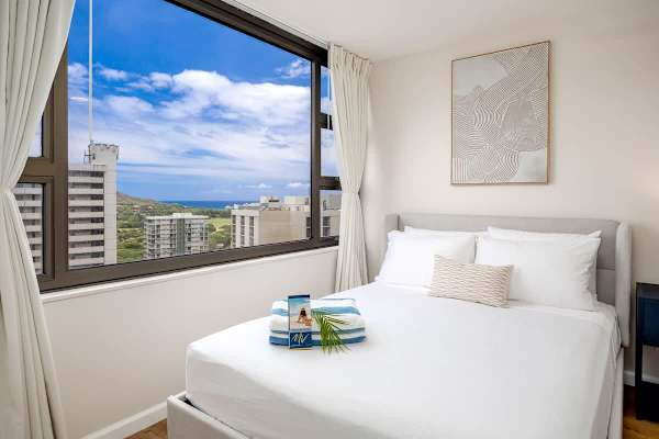 Wake up to breathtaking city, Diamond Head, and partial ocean views from the comfort of your bedroom, featuring a queen and a full-size bed.