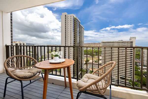 Enjoy a drink and the fresh air on this inviting balcony, offering stunning views of the city skyline and Diamond Head Mountain from a distance.