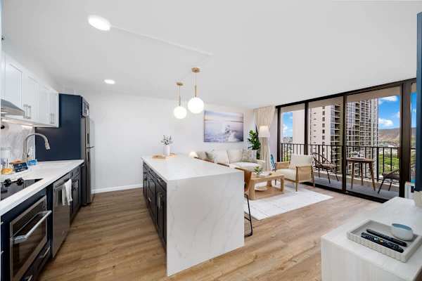 This stylish open-concept condo seamlessly blends a modern kitchen with a comfortable living area, leading out to a private balcony with scenic views.