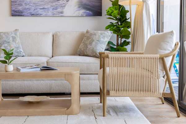 Relax in style in this inviting living space, featuring a comfortable sofa, a chic coffee table, and a unique woven armchair.