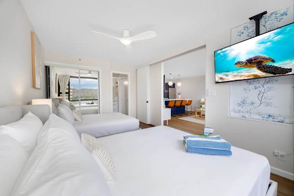 The bedroom features a queen and a full-size bed, a 50" flat-screen TV, a ceiling fan, a closet, and easy access to the bathroom.