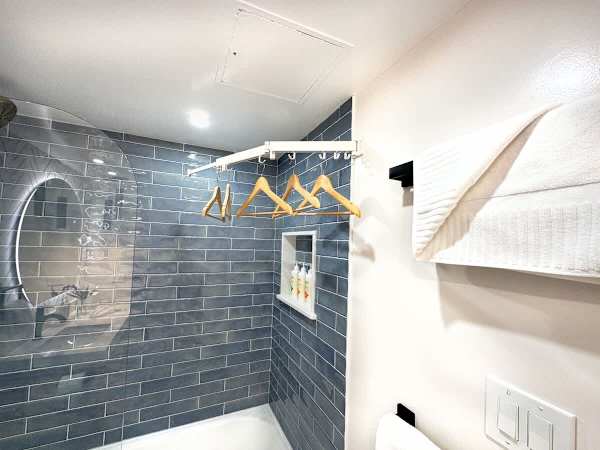 This bathroom features a clever drying rack and chic modern tiling, making it both practical and pleasing to the eye.