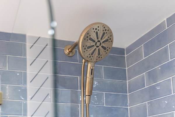 Start your day refreshed with a luxurious shower in the modern bathroom, featuring a stylish brushed-gold showerhead.