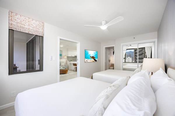 Relax in the bedroom, featuring 2 cozy queen beds and convenient access to a private bathroom.