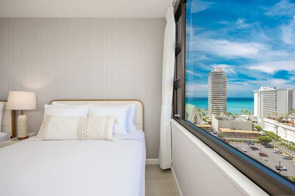 Wake up to stunning ocean and city views from the comfort of your bed in this bright, inviting bedroom.