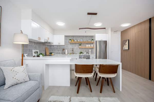Gather and dine at the quartz table in this open-concept space, perfectly integrated with a modern kitchen and a comfortable living area.