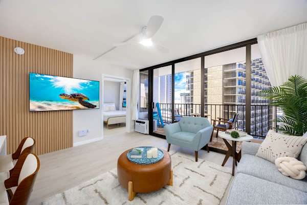 Relax in this bright living area with a 65-inch smart TV, enjoying seamless indoor-outdoor living with a sliding glass door that opens to the lanai.