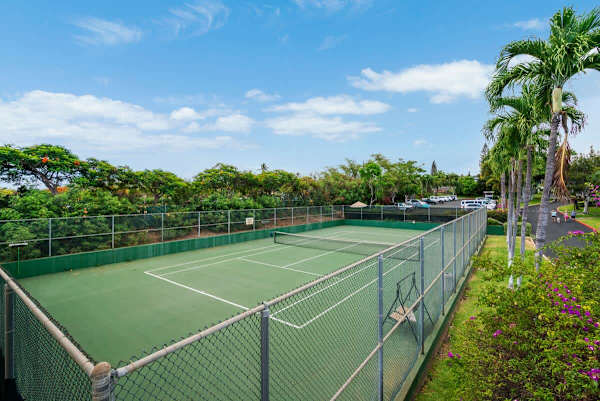 Grab your racket and enjoy a friendly match on the well-maintained on-site tennis court, surrounded by lush tropical landscaping under a beautiful sunny sky.