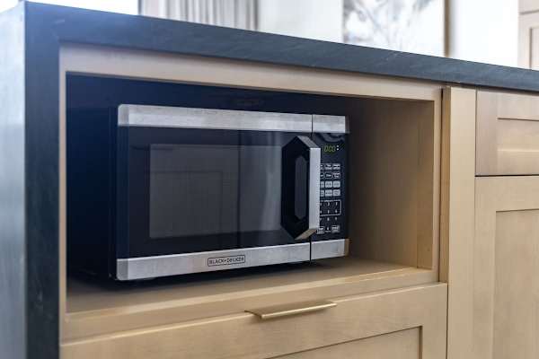 For quick heating or reheating, you have a convenient Black+Decker microwave tucked neatly into the island cabinetry!