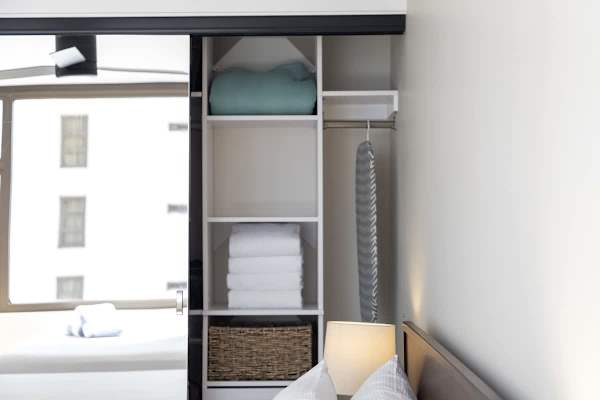 For your convenience, this organized closet provides plenty of storage space, extra pillows, fresh towels, and a handy ironing board for keeping your clothes neat!
