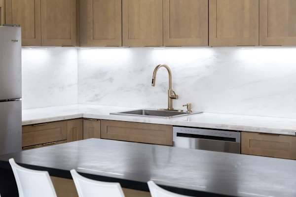 Take a look at your sleek kitchen workspace, featuring a beautiful marble-look backsplash, modern gold-tone faucet, and a convenient dishwasher to make clean-up after meals a breeze!