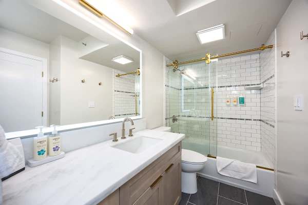 Freshen up in this beautiful, modern bathroom featuring a gorgeous marble vanity, subway tile in the tub/shower combo with stylish gold accents, and complimentary toiletries you'll need!