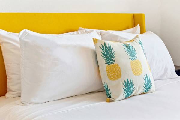 Rest easy against the vibrant yellow headboard and soft white pillows in your primary bedroom.