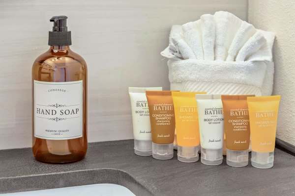 Enjoy the convenience of complimentary, high-quality bath amenities, including hand soap, body lotion, shampoo, and shower gel, provided for your comfort.
