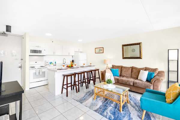 The living room features a queen-size sleeper sofa, coffee table, chair, and countertop with 4 bar stools!