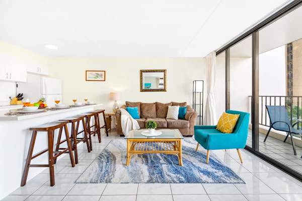 The living room features a pull-out sleeper sofa, coffee table, chair, and countertop with 4 bar stools!