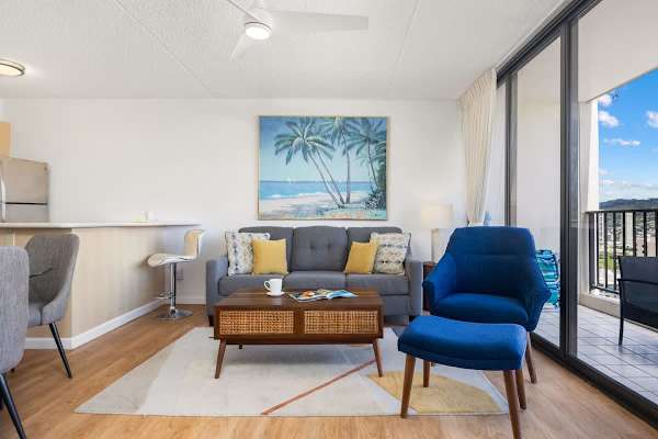 Relax in the bright, modern living room that features a comfortable sofa and a stylish accent chair, with seamless access to the balcony.